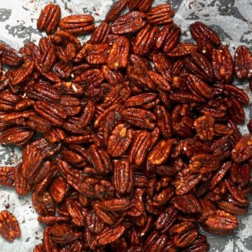 A handful of homemade candied pecans on a tray