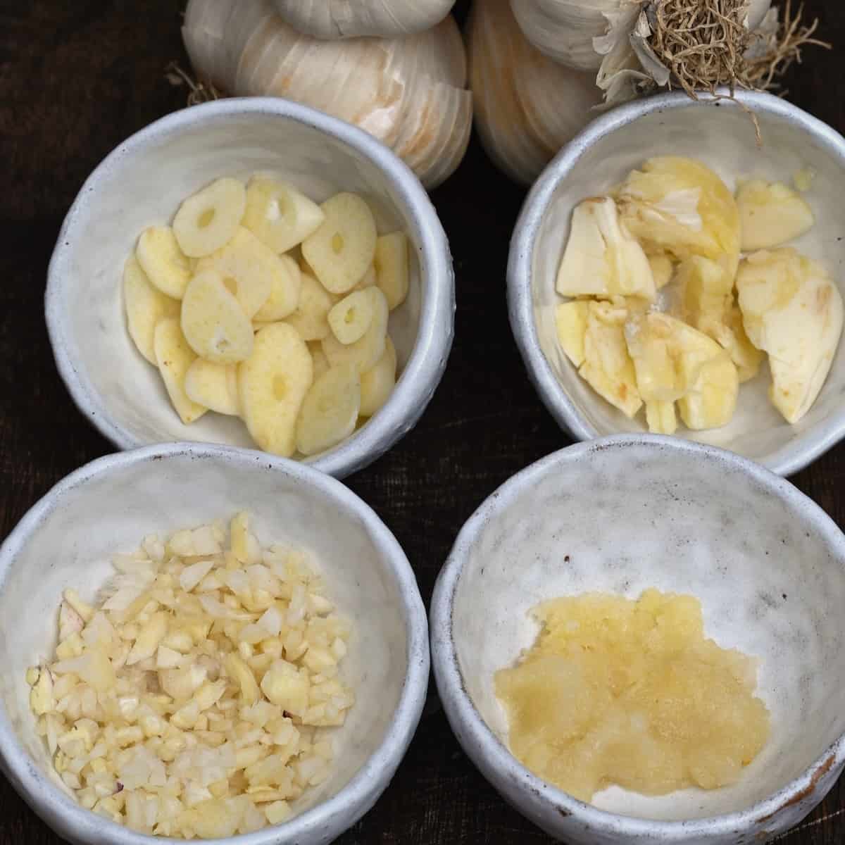 Little bowls with sliced, crushed, minced and pressed garlic