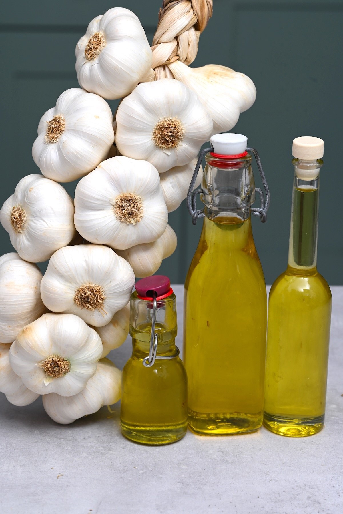 Garlic heads and three bottles with garlic oil