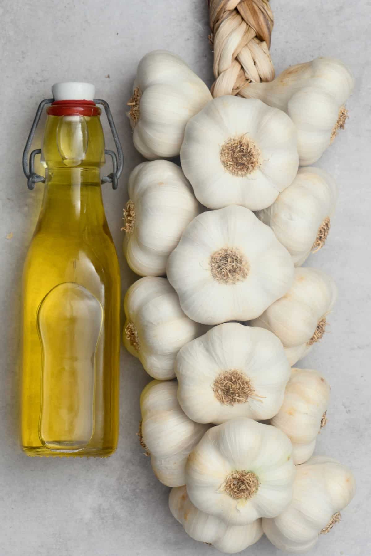 Garlic-infused oil in a bottle and garlic heads