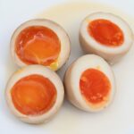 Two ramen eggs with jammy yolks cut in half