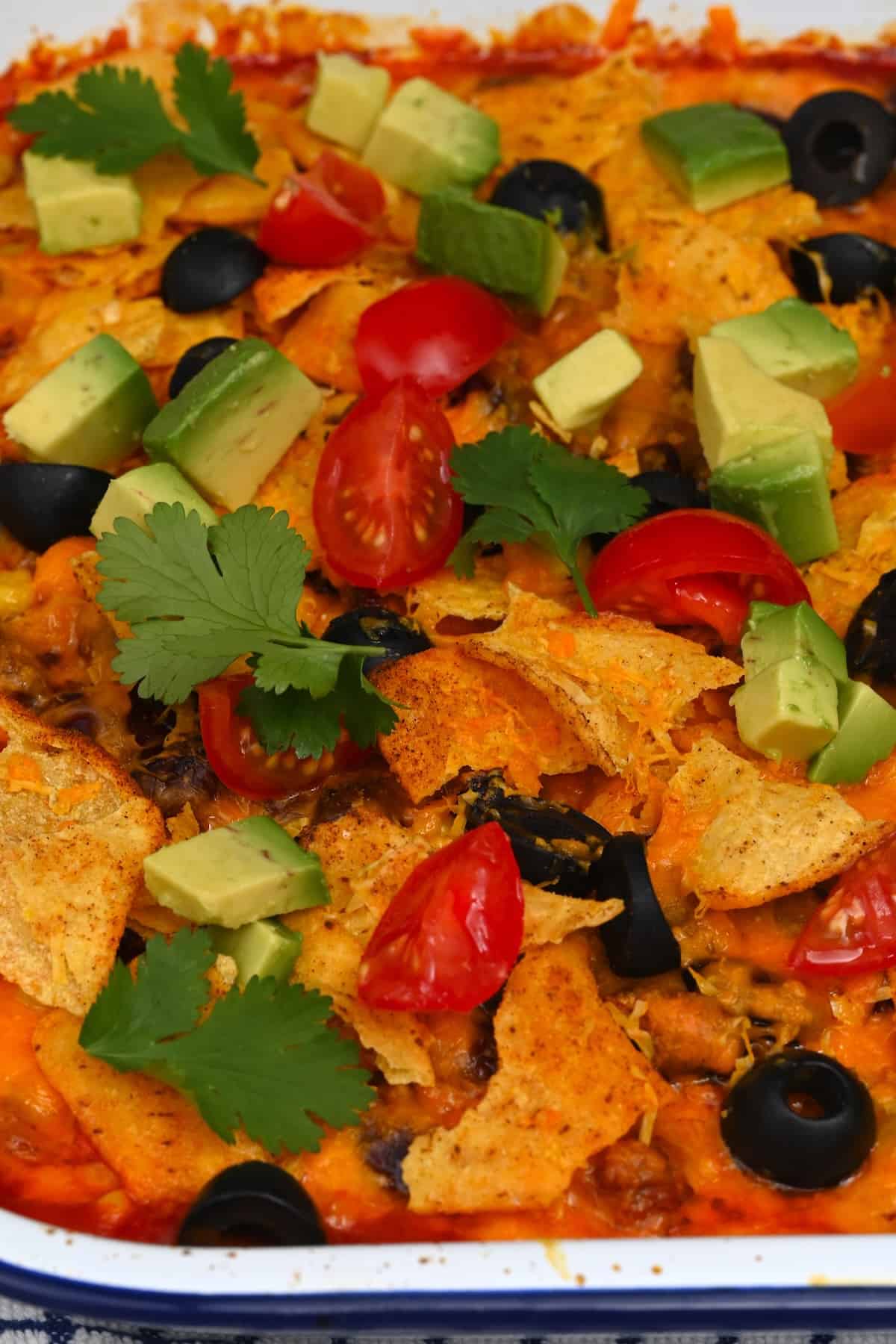 Freshly baked taco casserole topped with cherry tomatoes and avocado