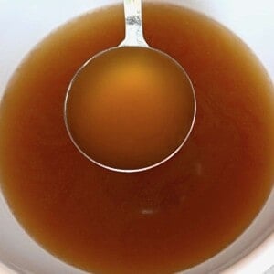 A ladleful of homemade beef broth