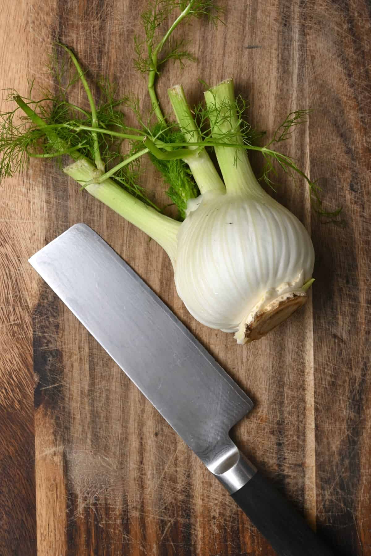 A bulb of fennel and a knife on a chopping board
