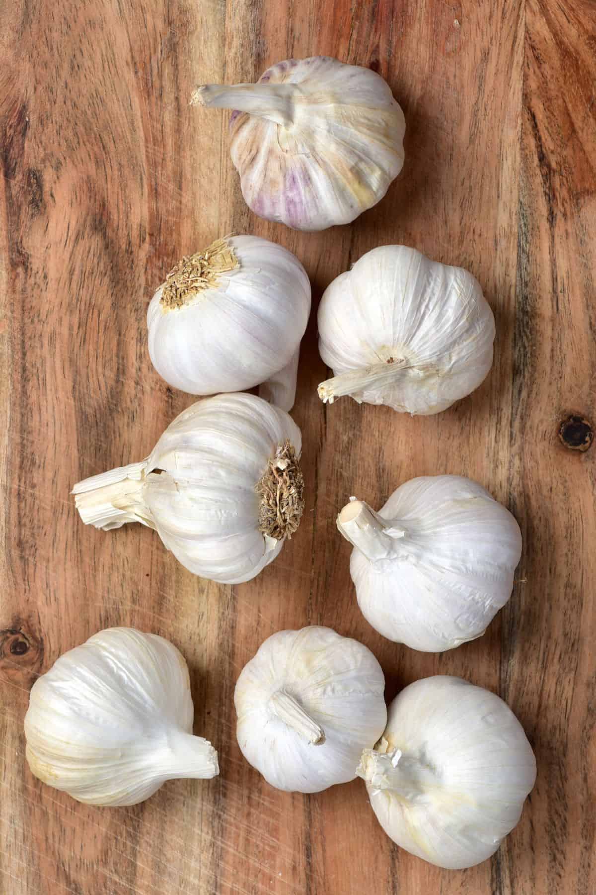 Eight full heads of garlic on a chopping board