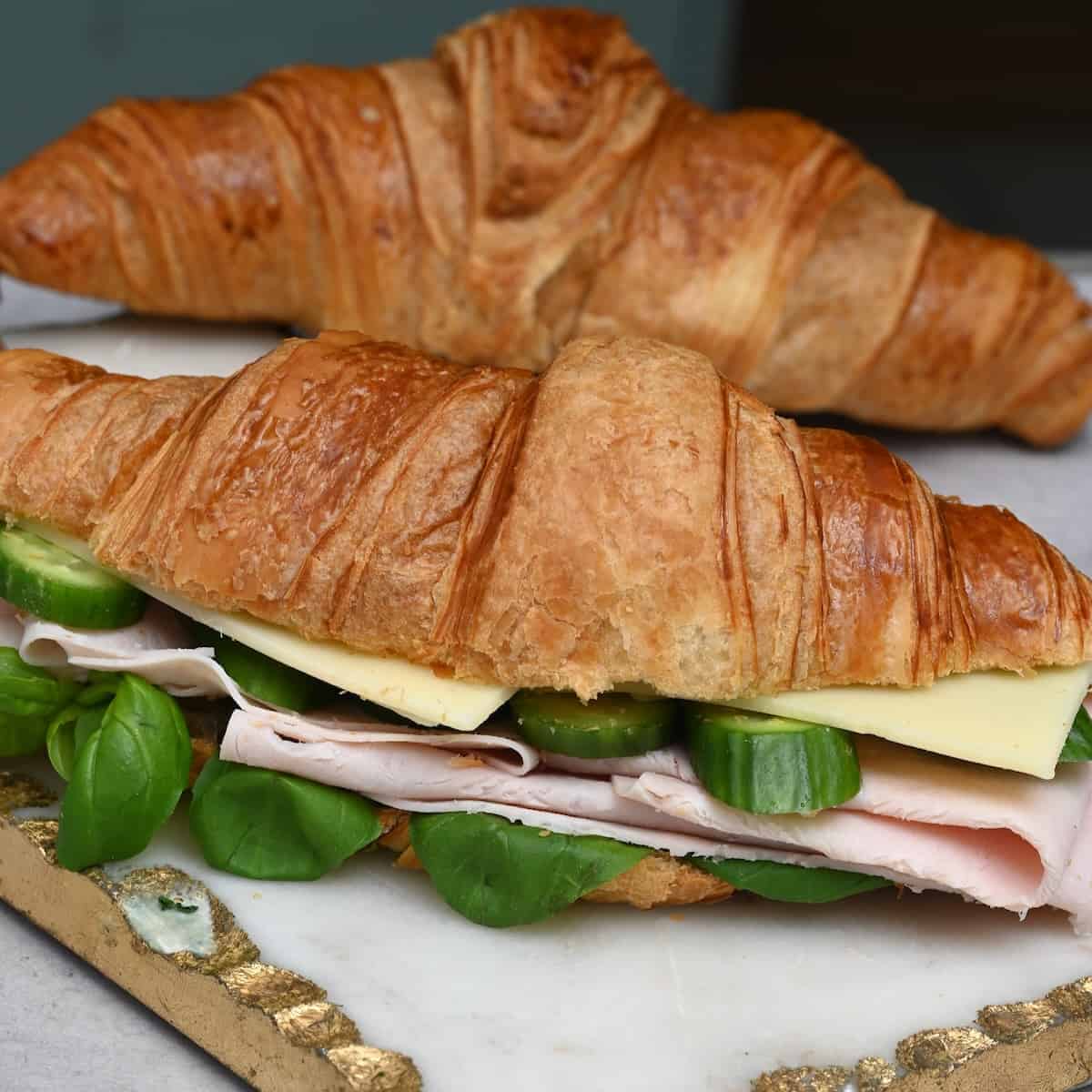 A croissant sandwich filled with cheese and ham