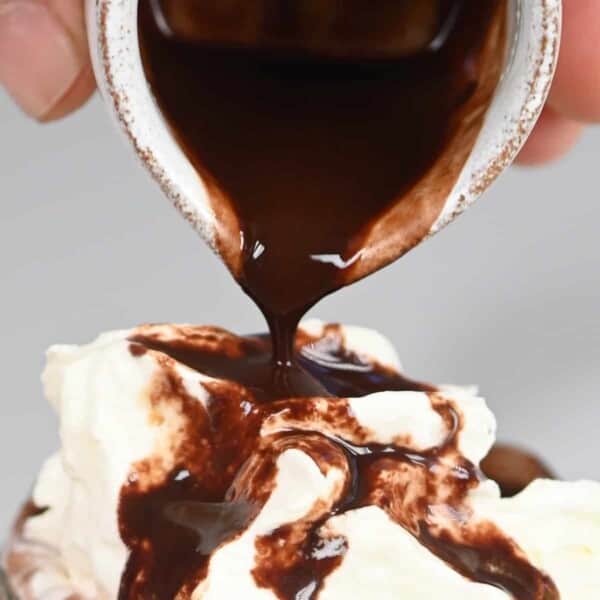 Pouring homemade chocolate syrup over a drink with whipped cream