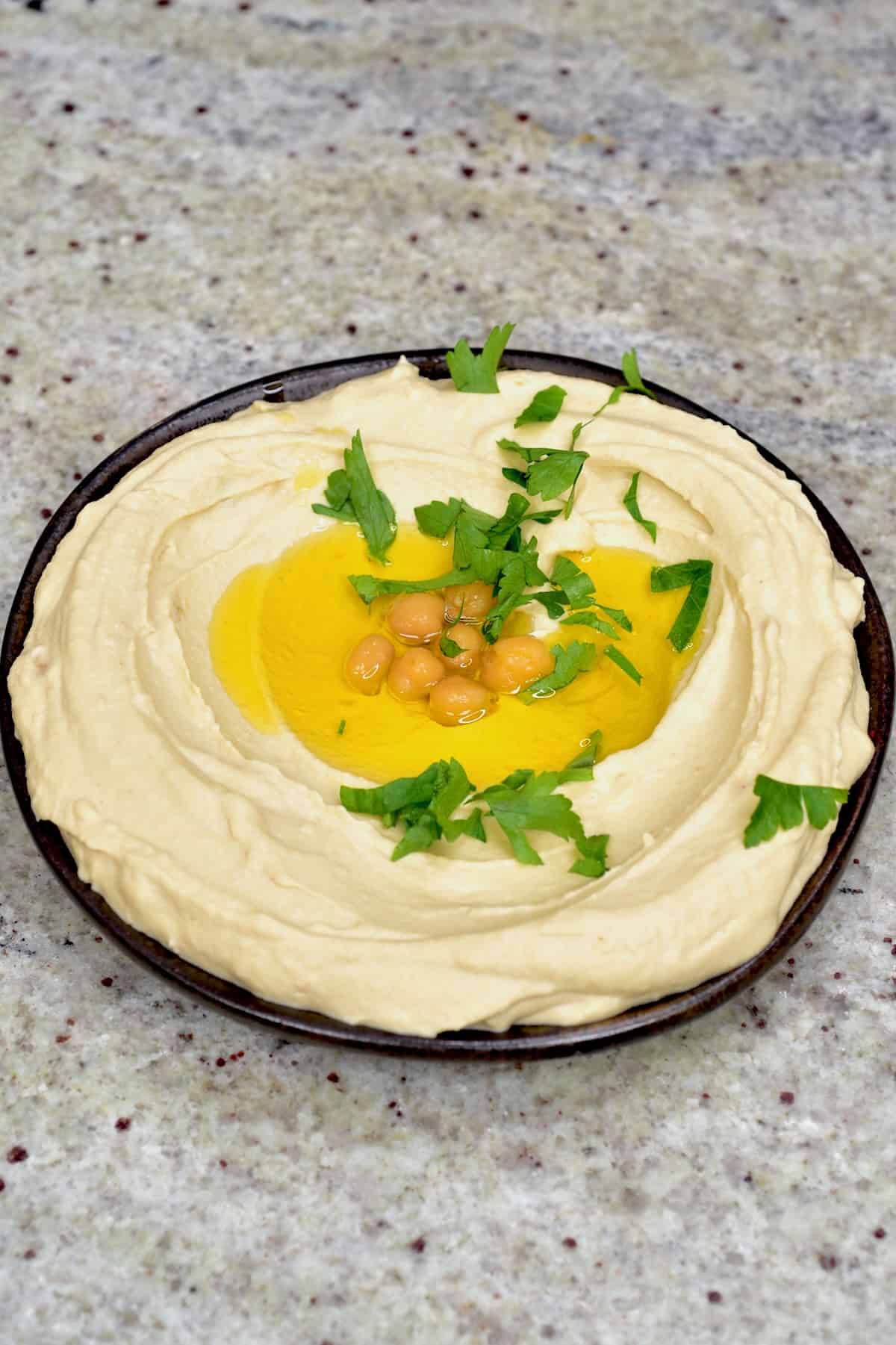 A bowl with homemade hummus topped with olive oil