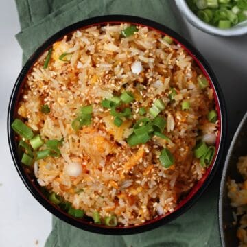 A serving of egg fried rice topped with scallions and sesame sees