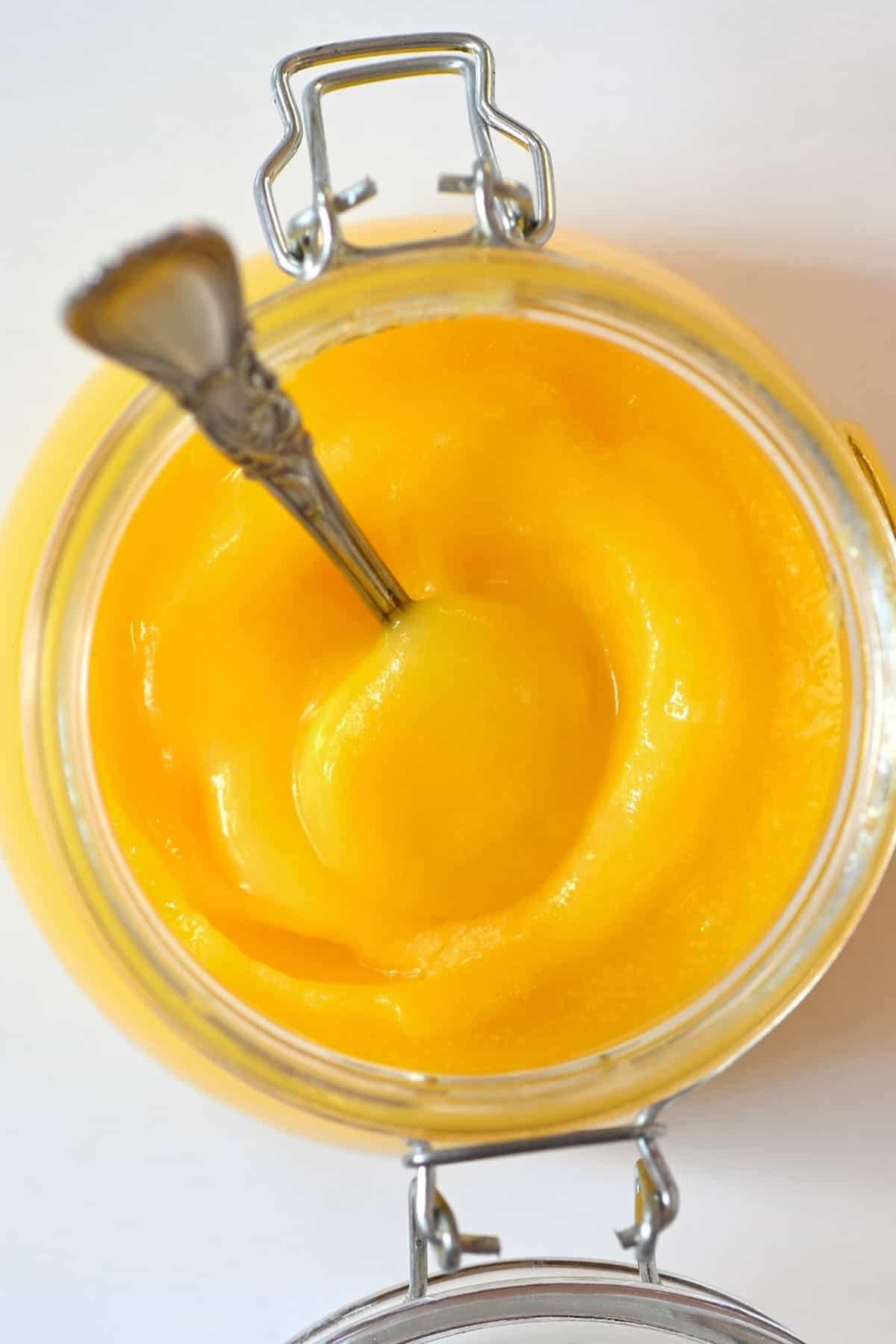 A jar with homemade ghee with a spoon dipped in it