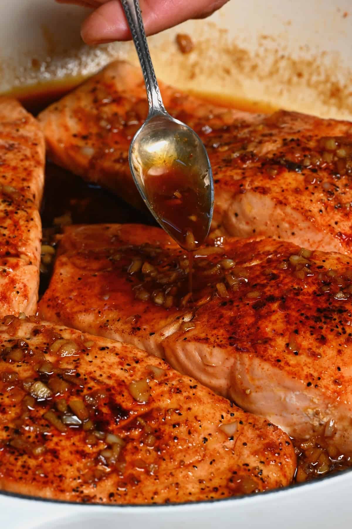 Pouring honey sauce over salmon