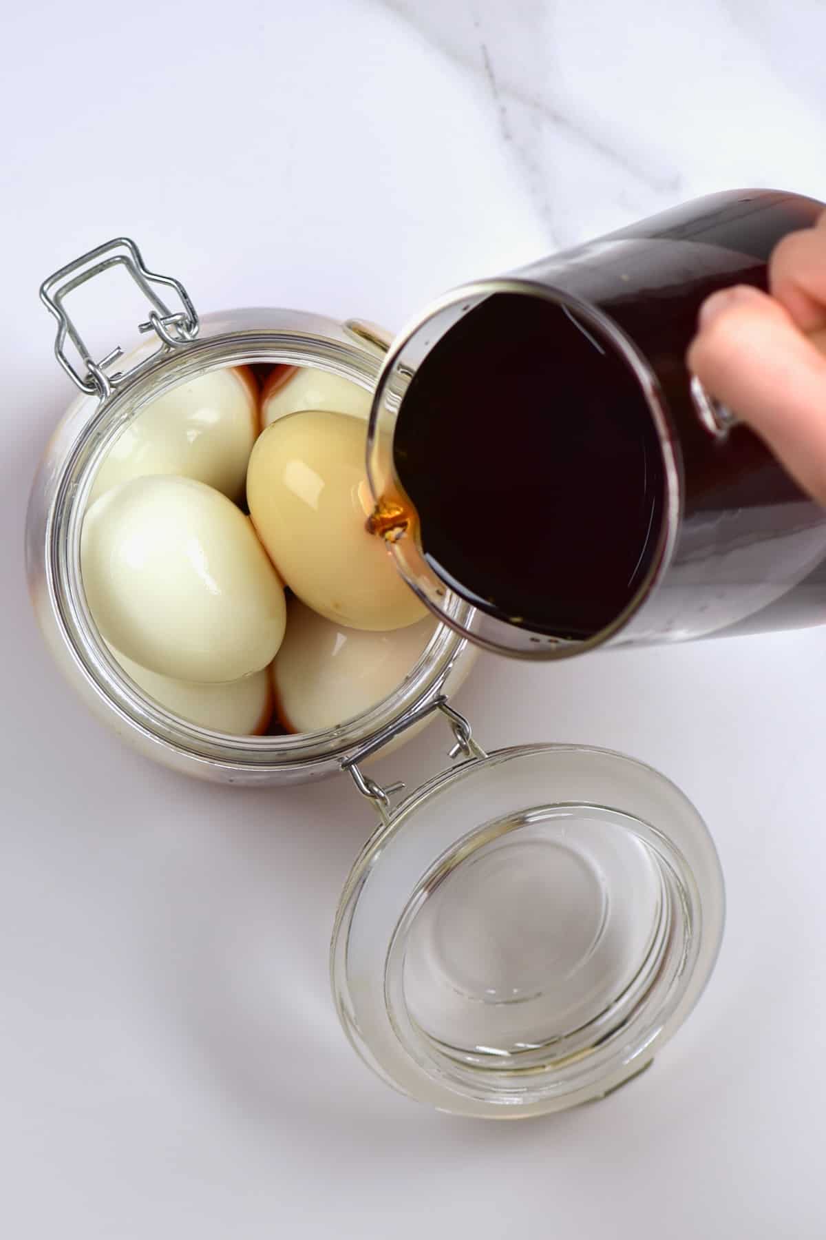 Pouring marinade over boiled eggs