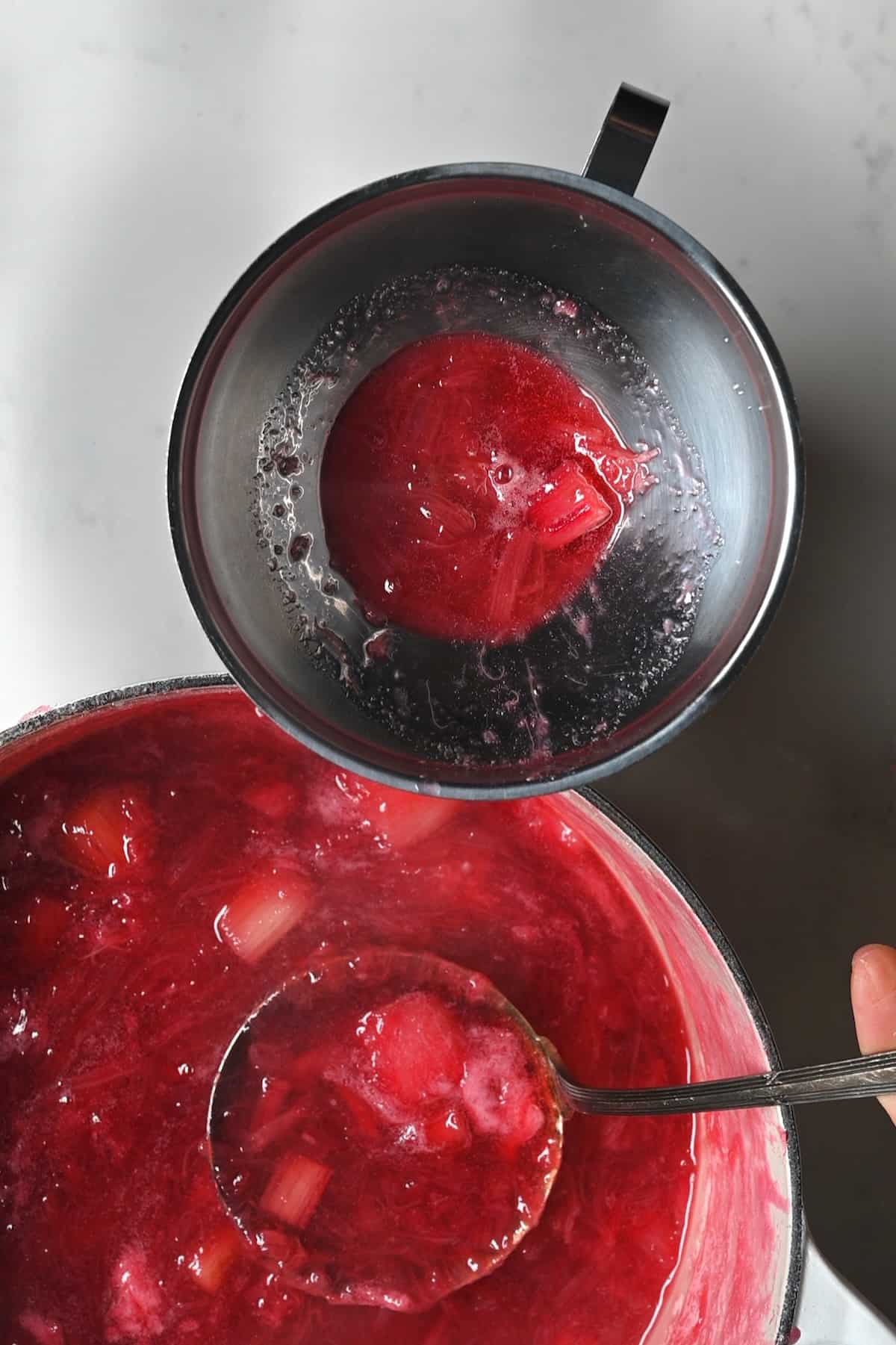 Spooning rhubarb jam into a jar