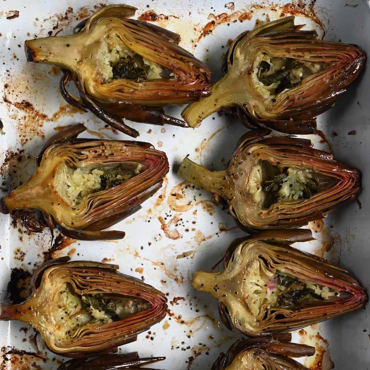 Roasted artichoke halves in a baking tray