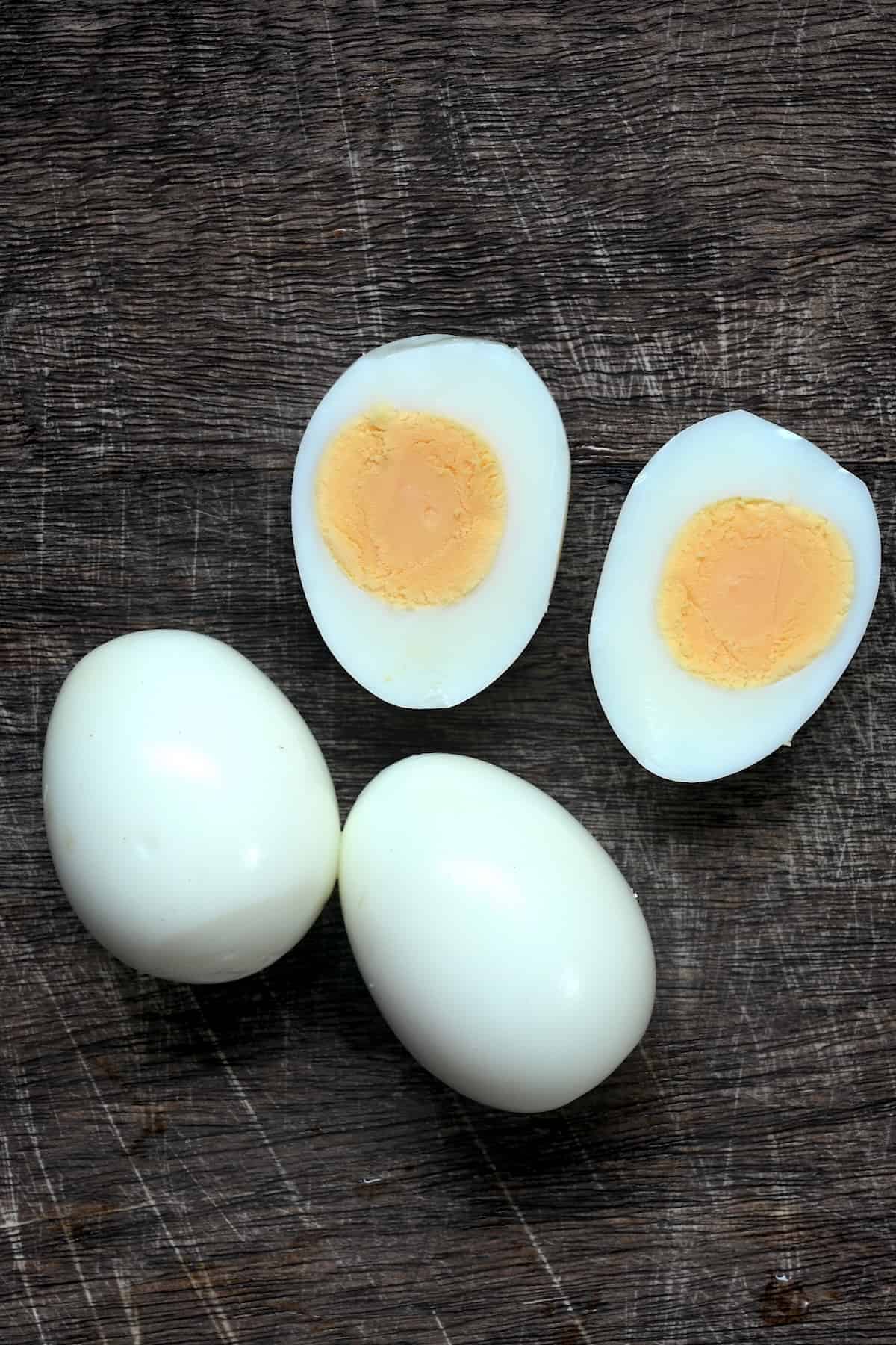 Three hard boiled eggs one of them cut in two