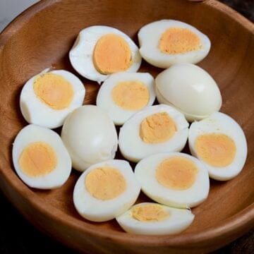 Seven peeled eggs cooked in air fryer, five of them cut in half