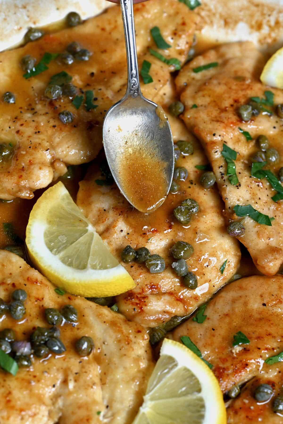 Pouring sauce over chicken piccata