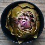 Steamed artichoke in a small bowl