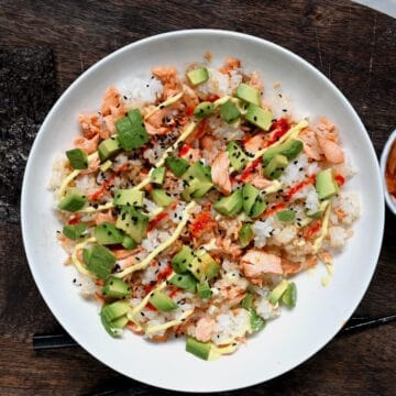 A salmon rice bowl topped with avocado and mayo