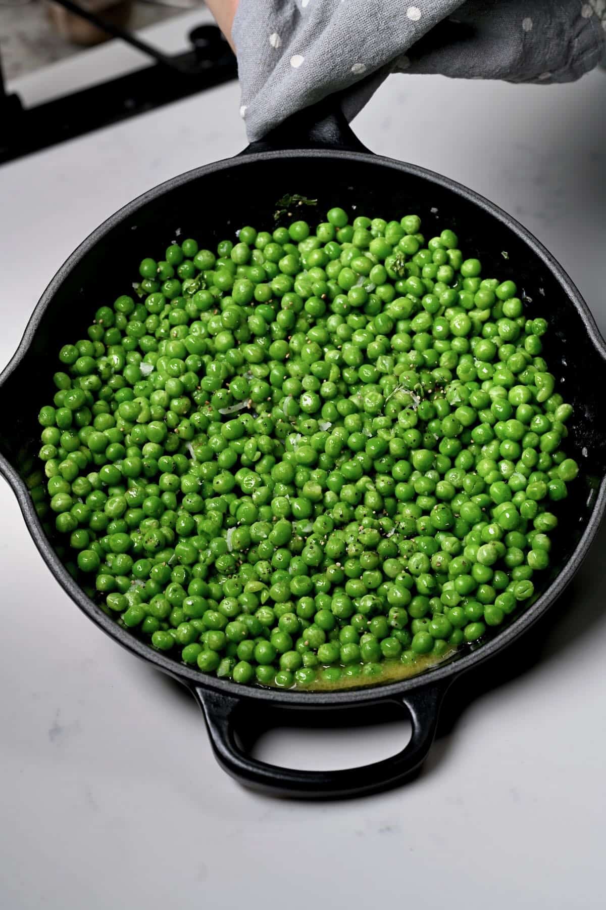 Sauteed green peas in a large skillet