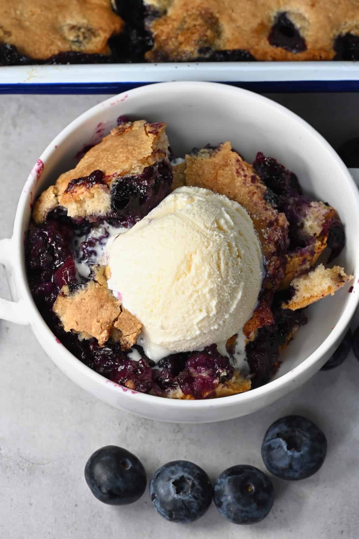 A serving of blueberry cobbler with a scoop of ice cream