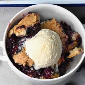 A serving of blueberry cobbler with a scoop of ice cream