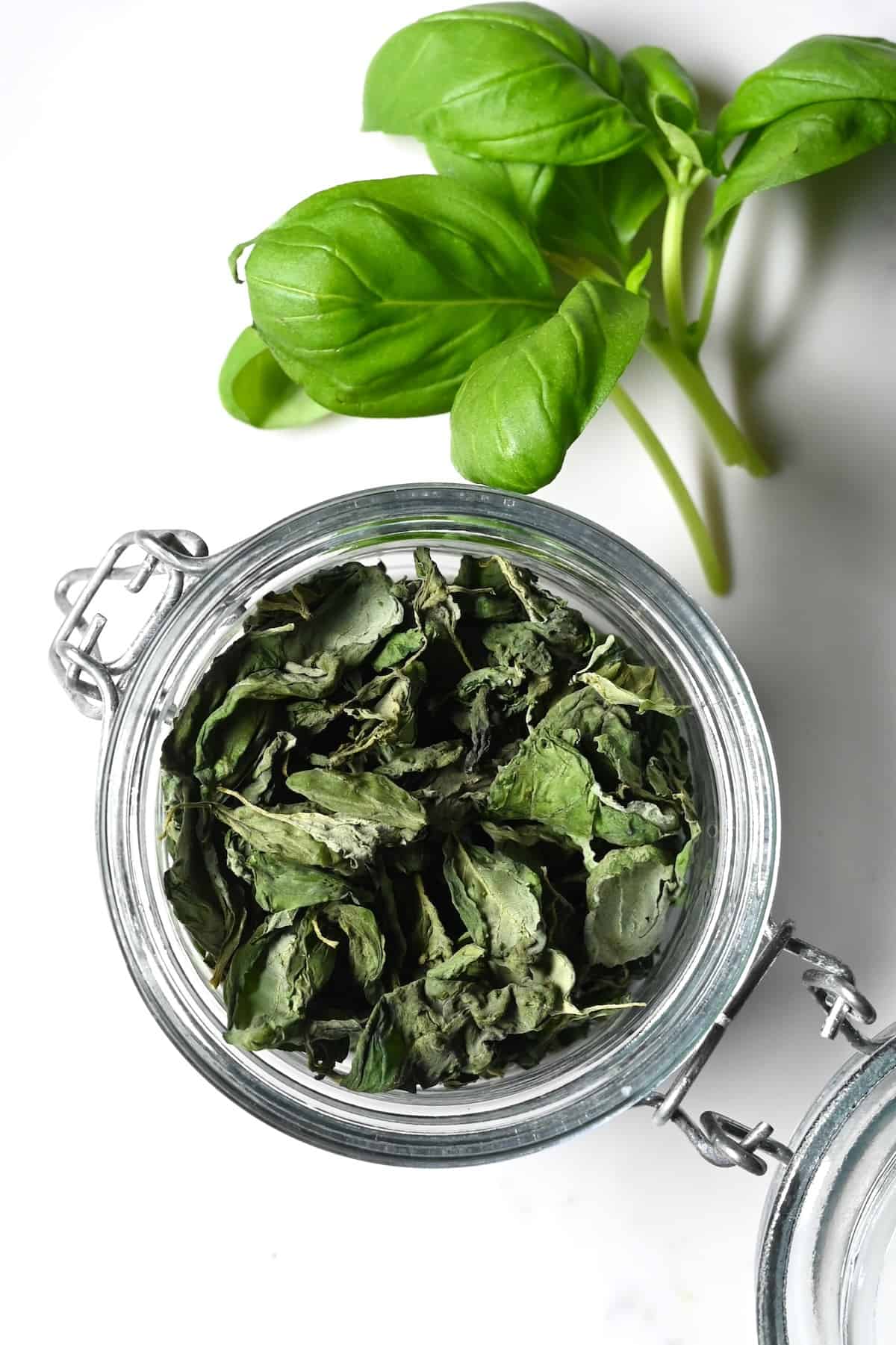 A jar with homemade dried basil leaves