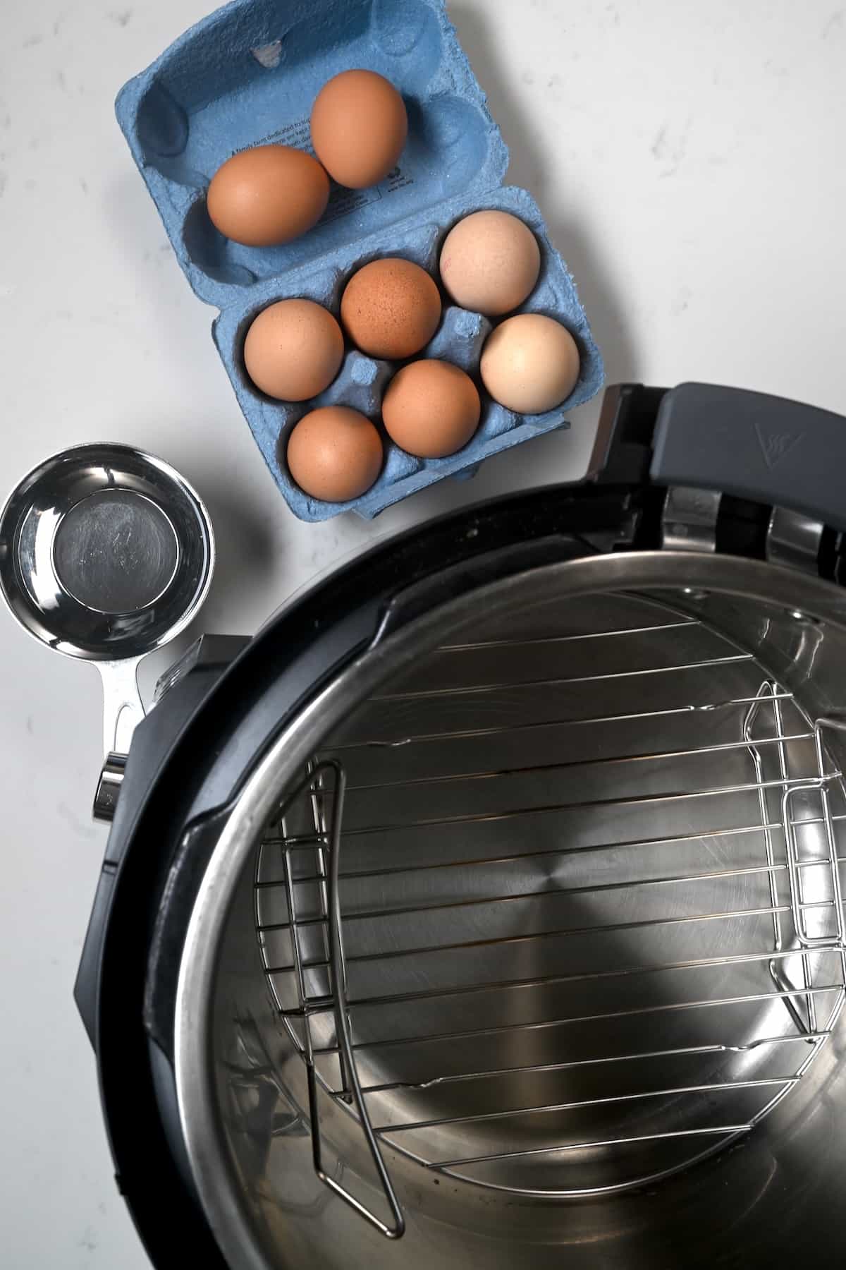 Instant pot, a box of eggs and a cup of water