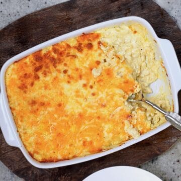 Baked mac and cheese in a baking dish and a serving on a plate