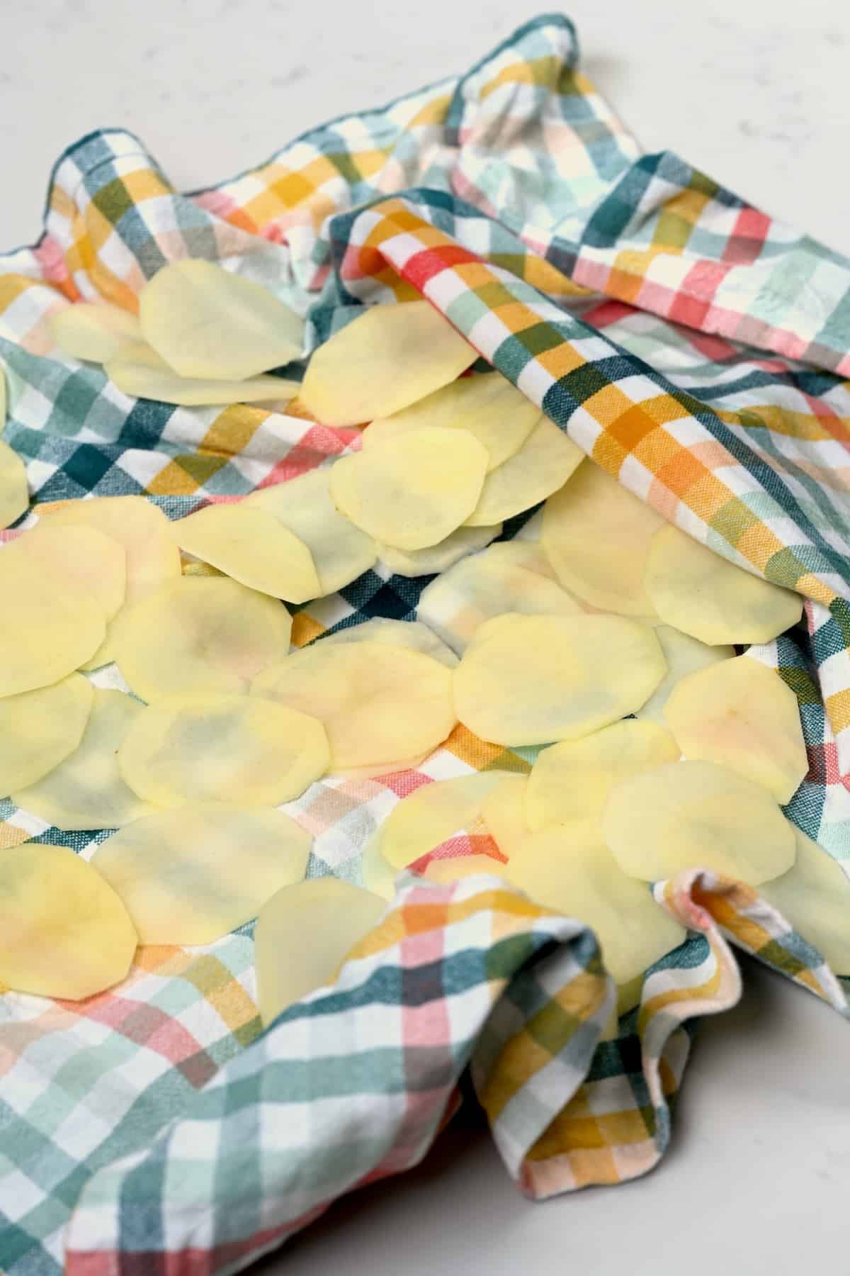 Drying potato slices with kitchen towel