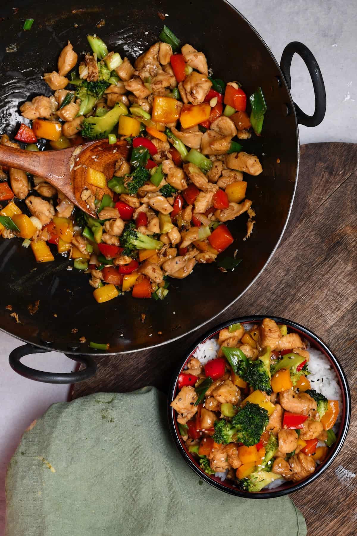Stir fried chicken in a wok and a serving of it