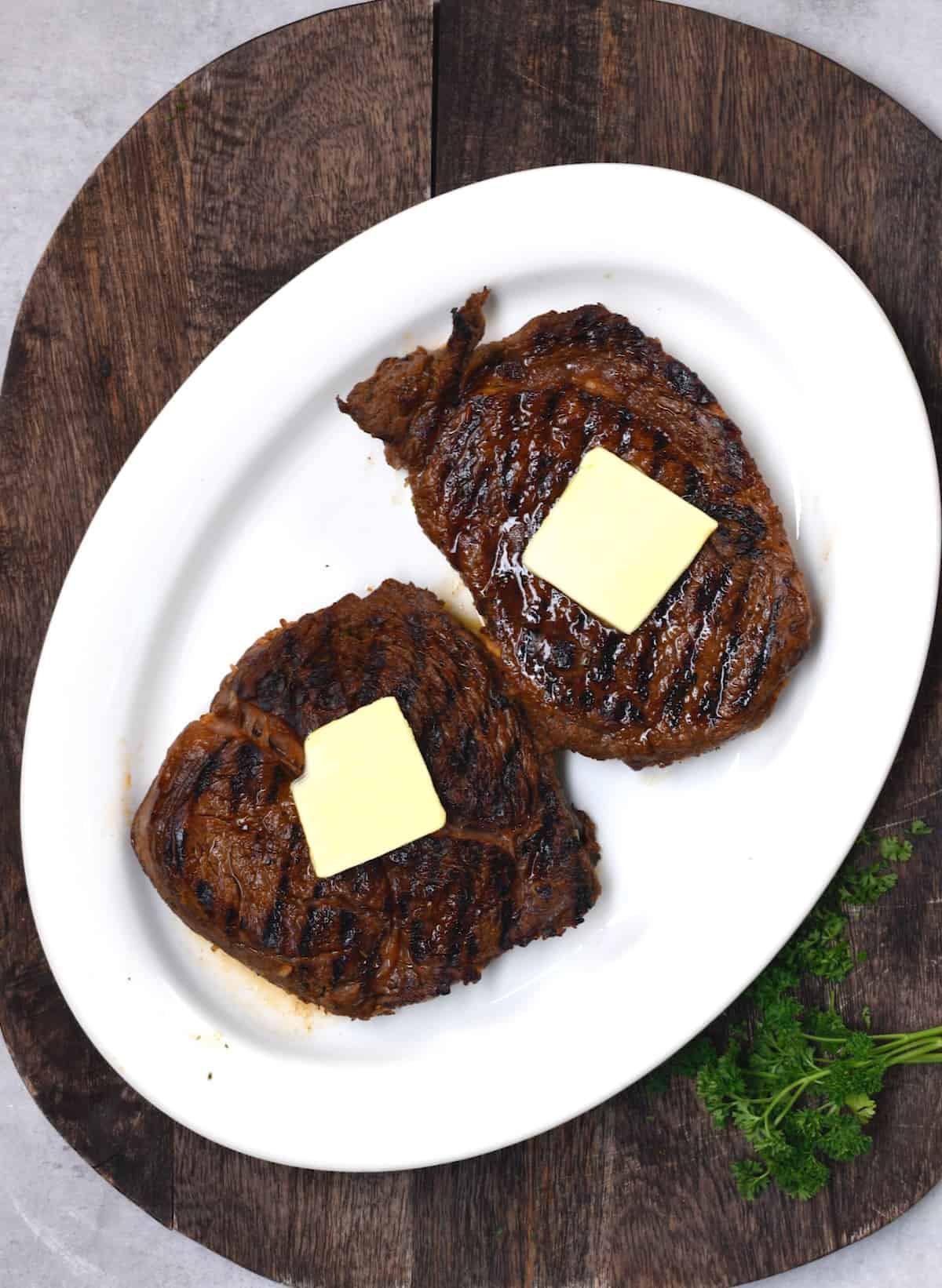 Cooked steaks topped with butter