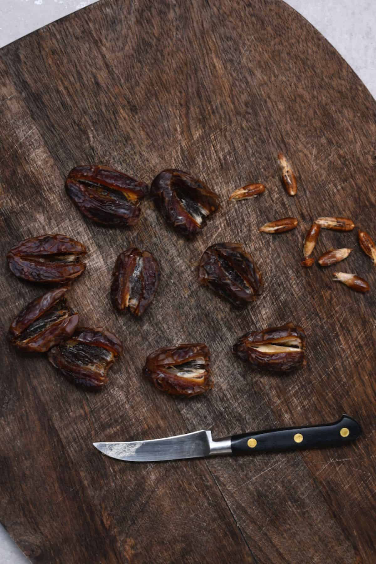 Deseeded dates and a knife on a board