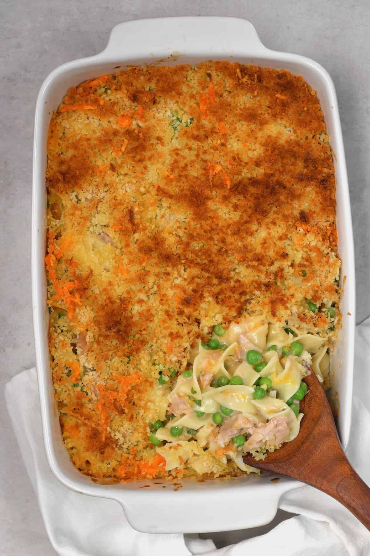 A serving spoon dipping in tuna casserole