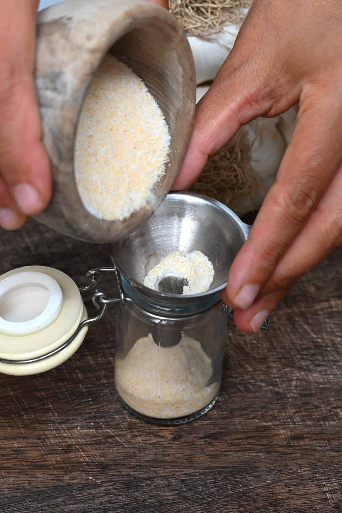 Placing garlic salt in a spice jar