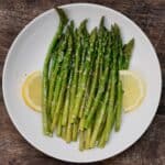 Roasted asparagus on a plate with lemon slices - 20