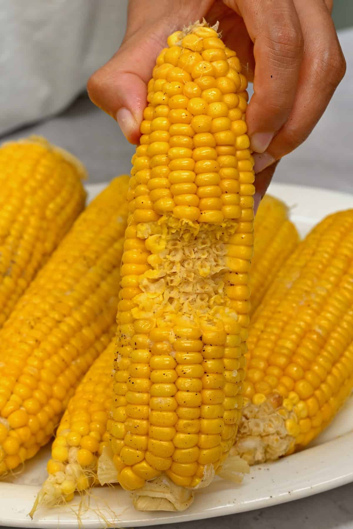 A cooked corn on the cob with a bite