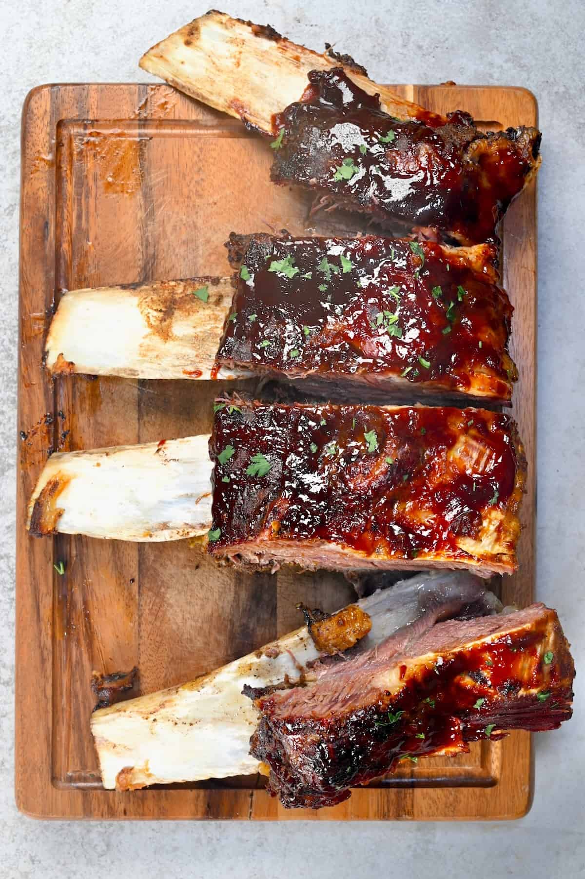 Four beef short ribs on a cutting board