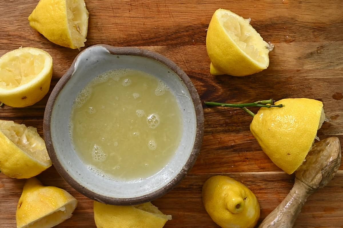 Juiced lemons and a bowl of lemon juice