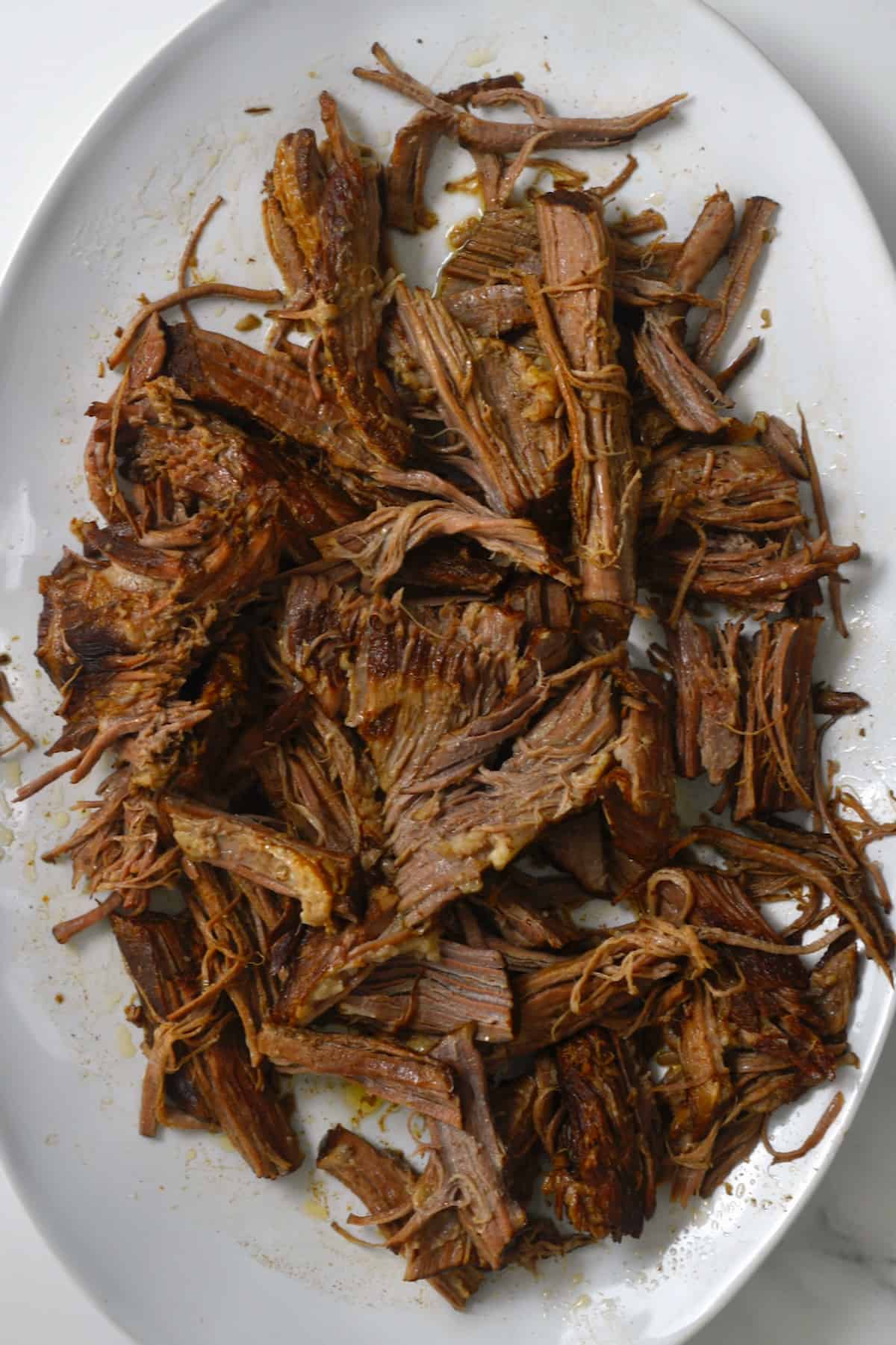 Shredded birria beef on a serving plate