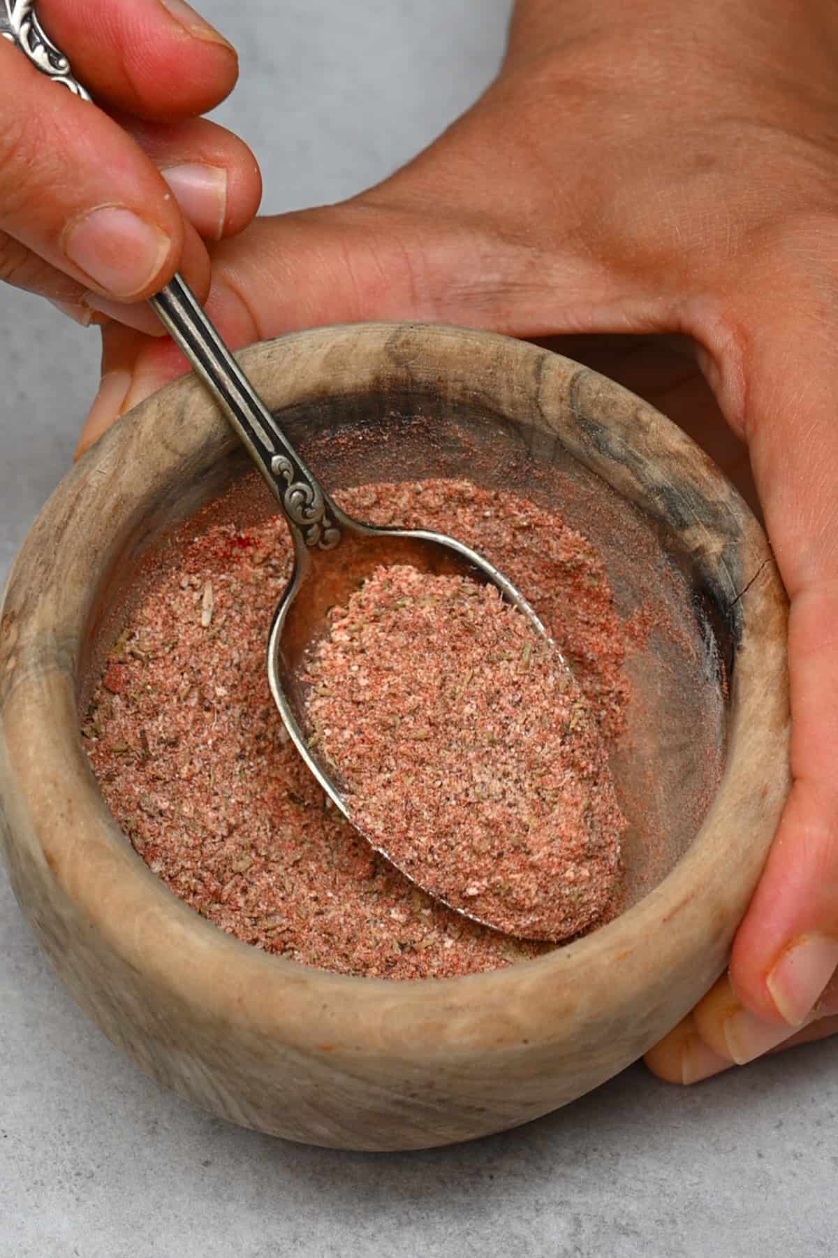Mixing chicken seasoning in a small bowl with a spoon