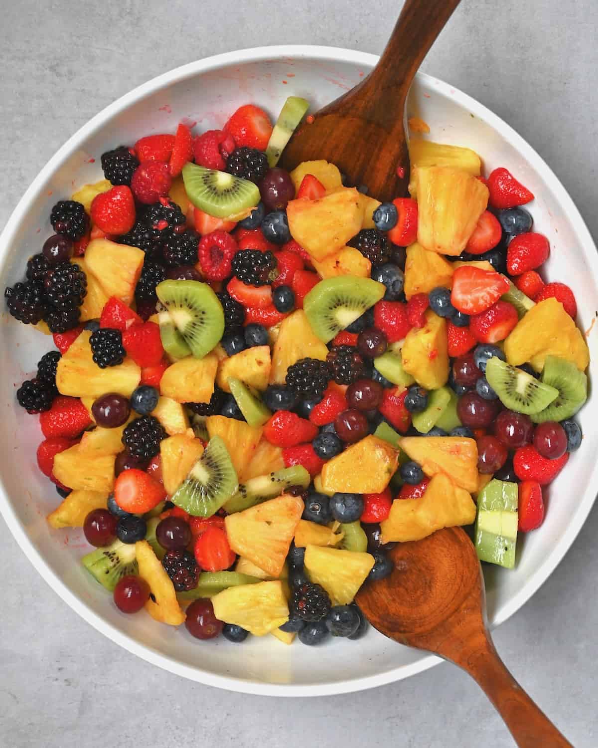 Mixing a fruit salad in a large bowl