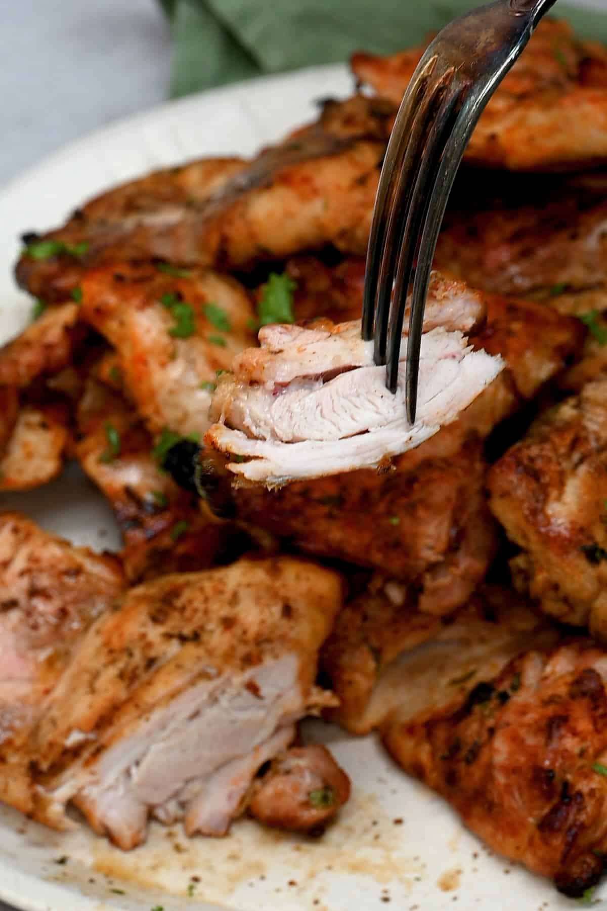 A forkful of grilled chicken thighs