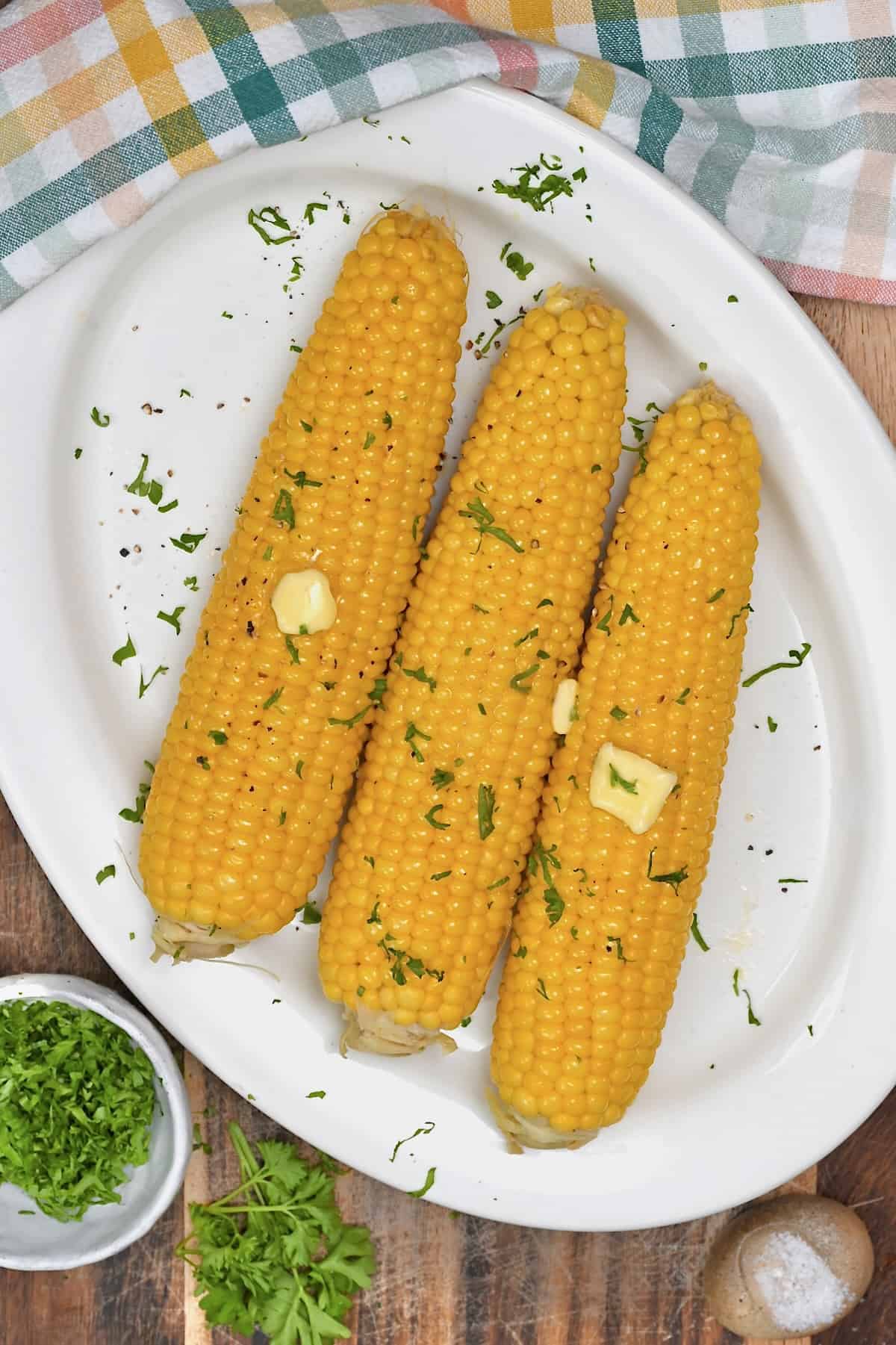 Boiled corn on the cob topped with butter and herbs