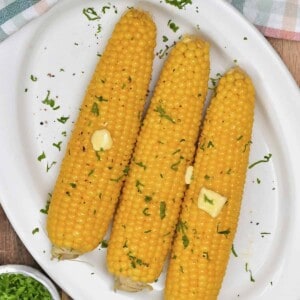 Boiled corn on the cob topped with butter and herbs