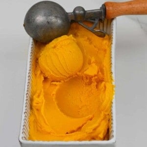 Homemade mango ice cream in a tub