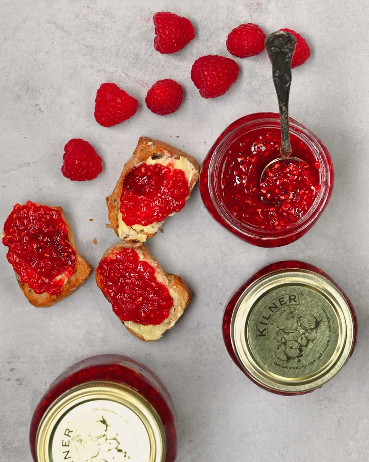 A jar of homemade raspberry jam and jam on bread