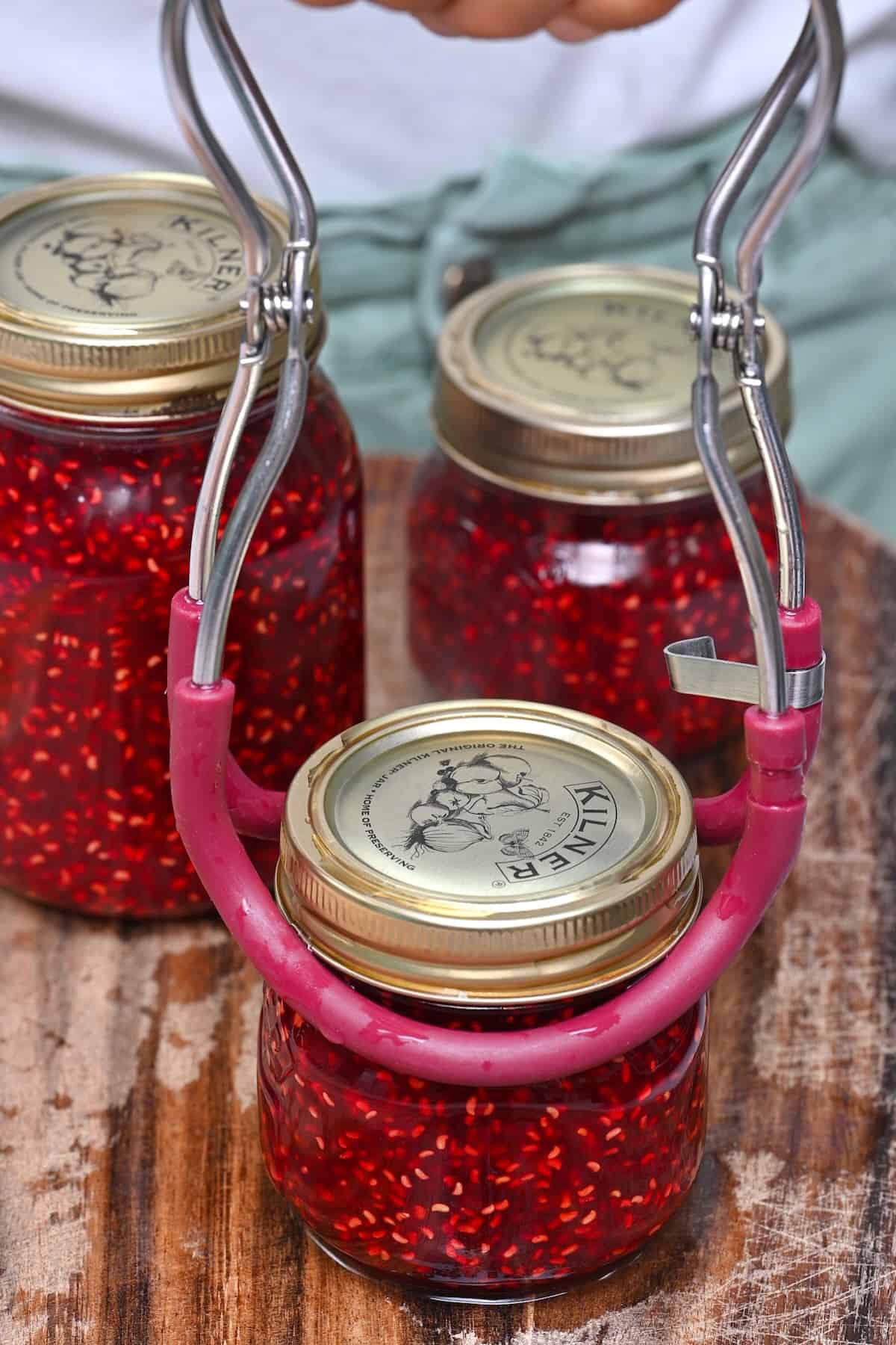 Placing a hot jar with jam on a wooden board