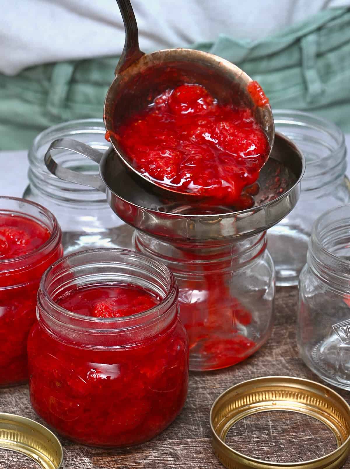 Filling jars with homemade strawberry jam