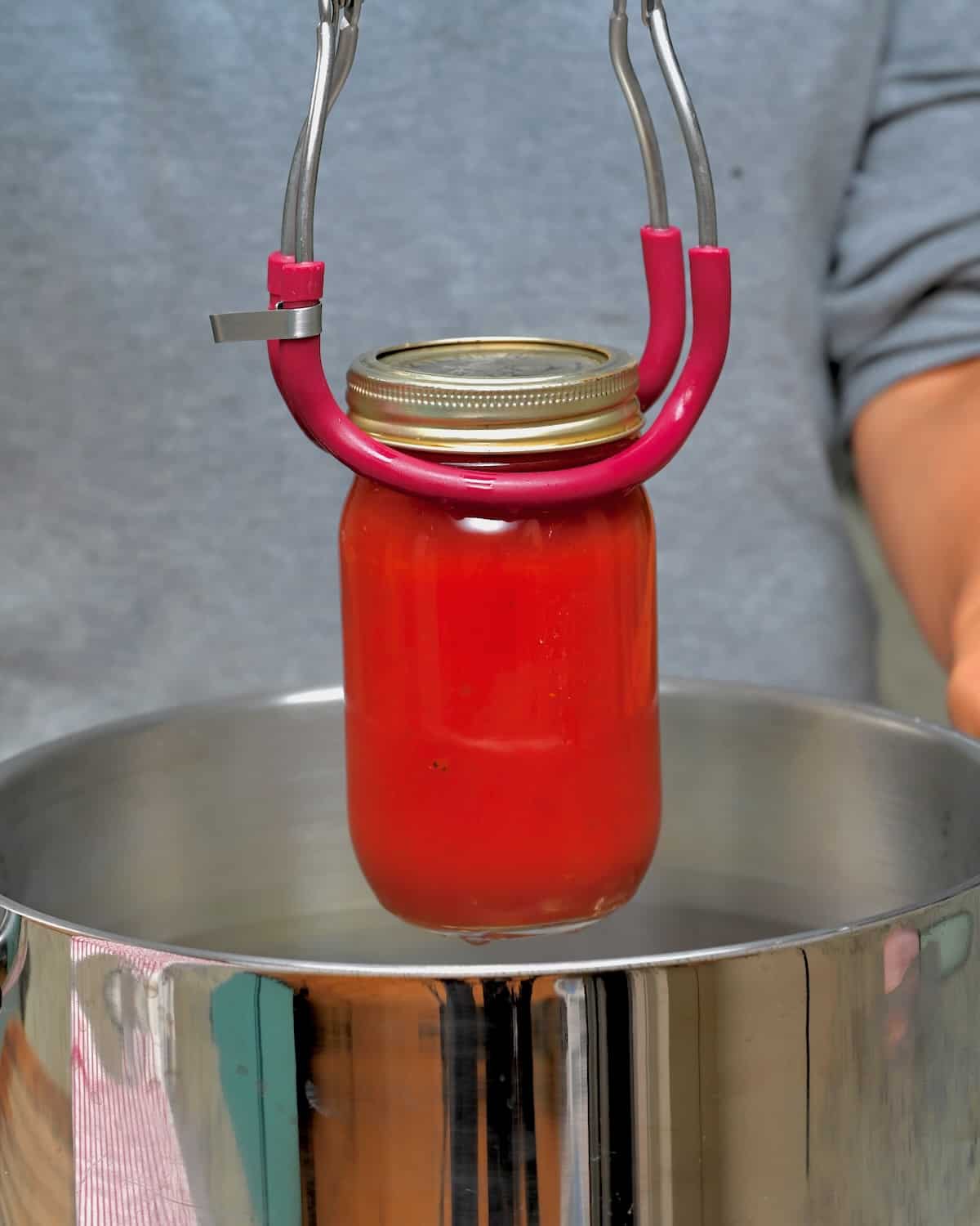 Placing a jar in a water bath canner